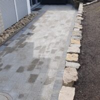 Pflaster und Natursteinmauer